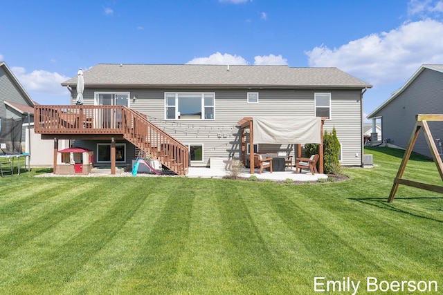 rear view of property with a patio, a trampoline, a deck, a lawn, and stairs