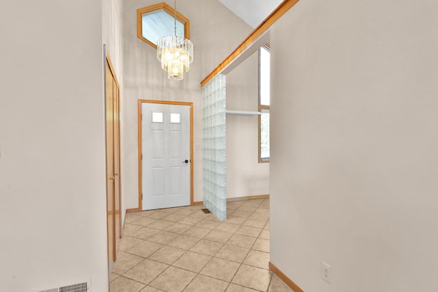 53201 Maranatha Ln, Wixom, MI 48393 - foyer entrance featuring a chandelier, light tile patterned flooring, baseboards, and high vaulted ceiling