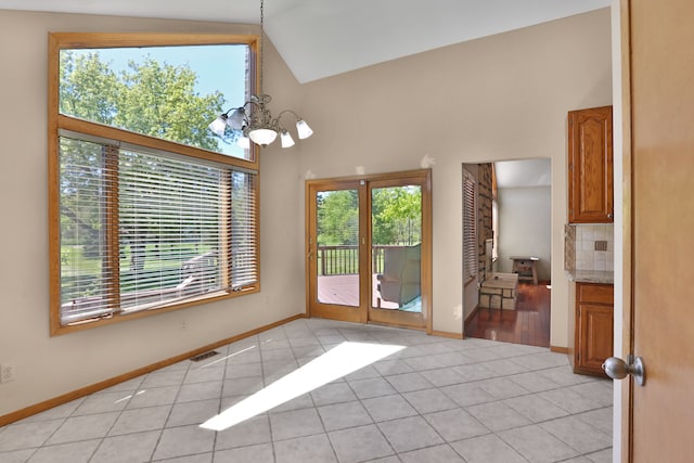 53201 Maranatha Ln, Wixom, MI 48393 - unfurnished dining area featuring a chandelier, light tile patterned floors, high vaulted ceiling, and baseboards