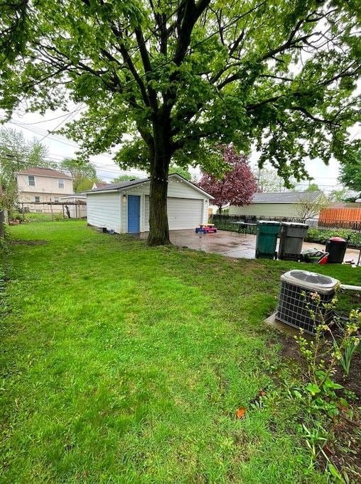 view of yard featuring fence, cooling unit, and an outbuilding