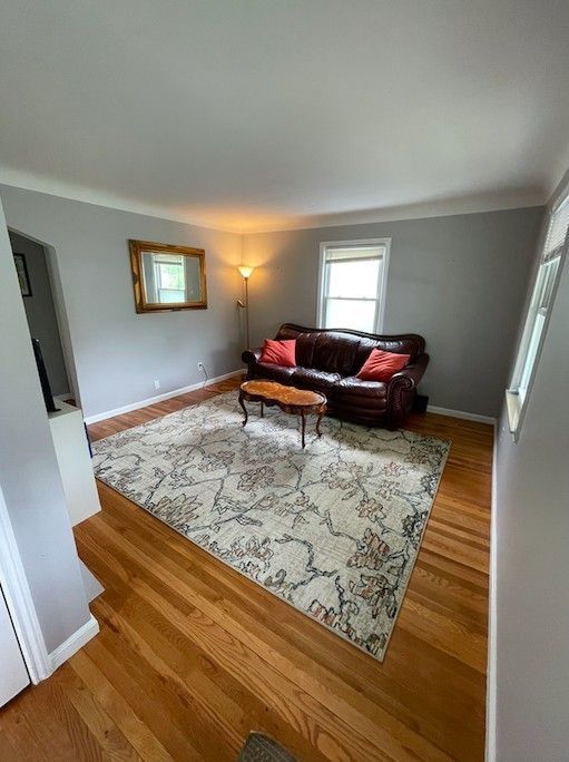 living area featuring baseboards and wood finished floors