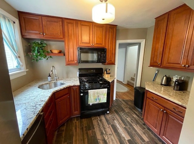 kitchen featuring dark wood finished floors, light stone countertops, black appliances, and a sink