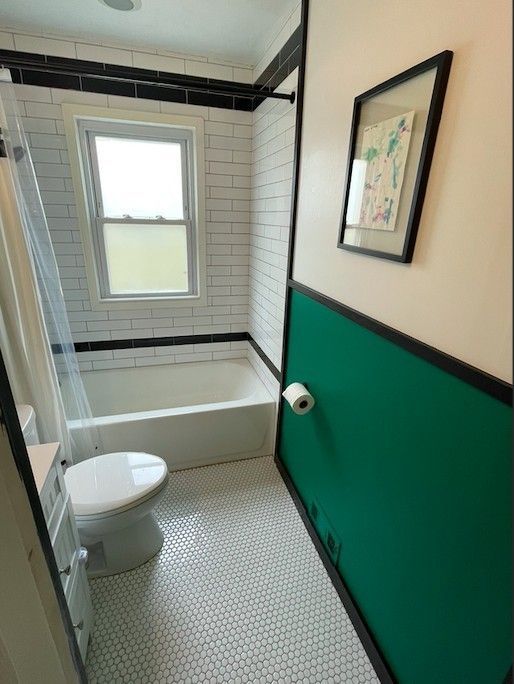 bathroom featuring vanity, toilet, tile patterned flooring, and shower / bath combo