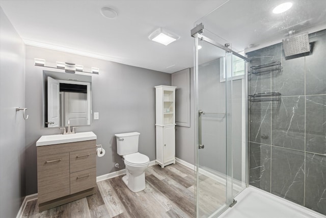 full bath featuring a shower stall, toilet, vanity, wood finished floors, and baseboards