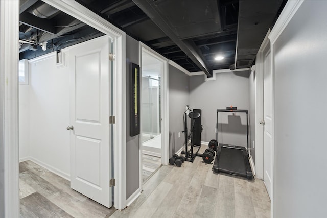 workout room with light wood-style floors and baseboards