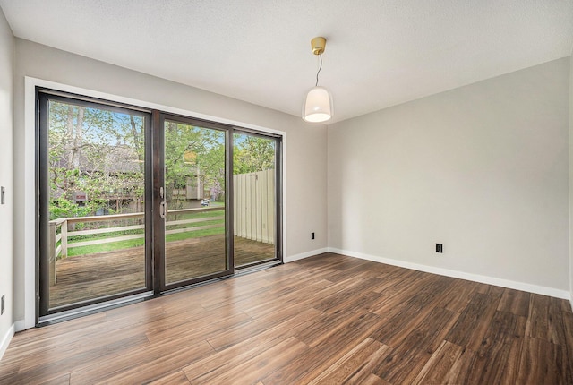 unfurnished room featuring wood finished floors and baseboards
