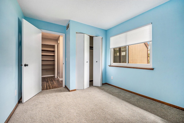unfurnished bedroom with baseboards, carpet flooring, and a closet
