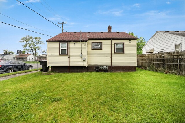 back of house featuring a chimney and a shingled roof