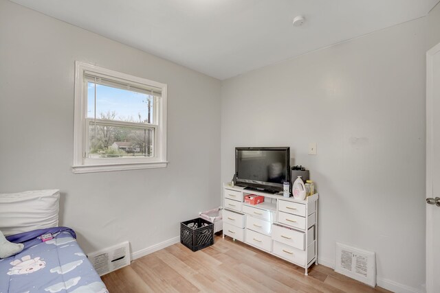 bedroom featuring light wood-style floors and baseboards