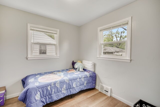bedroom with baseboards and wood finished floors
