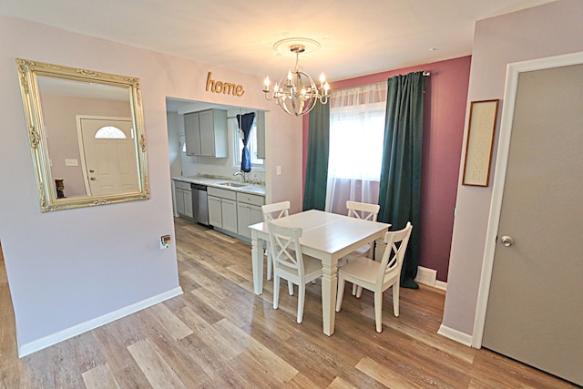 dining area featuring a chandelier, light wood finished floors, and baseboards