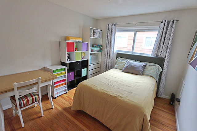 bedroom with wood finished floors and baseboards