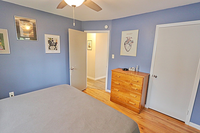 bedroom featuring light wood finished floors, a ceiling fan, and baseboards