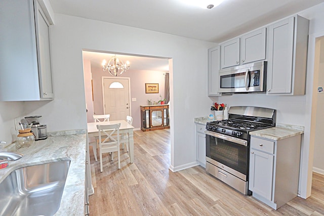 kitchen featuring appliances with stainless steel finishes, light wood-style flooring, and a sink