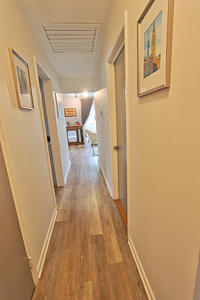 corridor with wood finished floors and baseboards