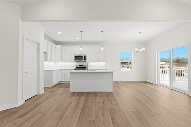 kitchen featuring appliances with stainless steel finishes, a chandelier, light wood-style flooring, white cabinets, and crown molding