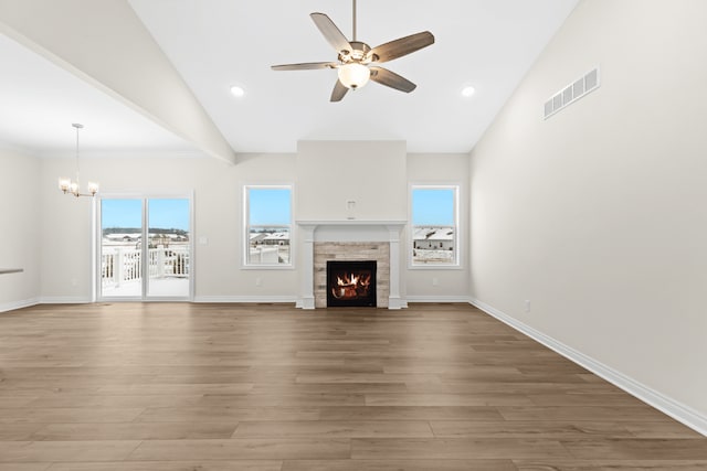 unfurnished living room with a ceiling fan, a chandelier, a lit fireplace, wood finished floors, and recessed lighting