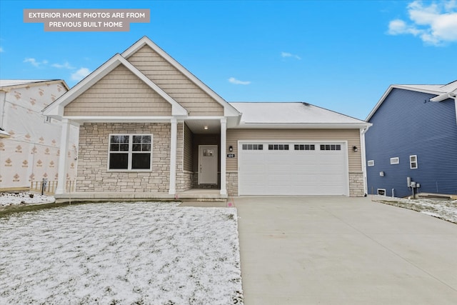 view of front of house with an attached garage, stone siding, and driveway