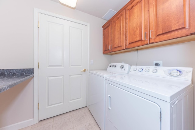 washroom with washer and clothes dryer, light tile patterned flooring, cabinet space, and baseboards