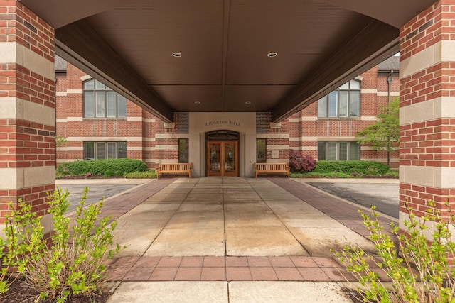 view of exterior entry featuring brick siding and french doors