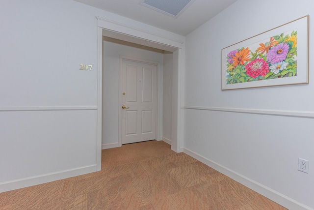 hall featuring carpet, baseboards, and visible vents
