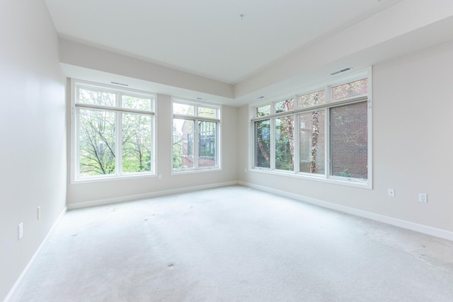 spare room featuring carpet flooring, visible vents, and baseboards