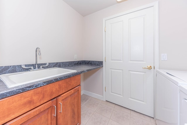 laundry room with light tile patterned floors, baseboards, cabinet space, and a sink