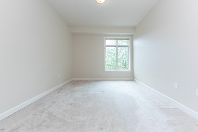 empty room with baseboards and light colored carpet