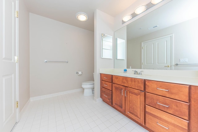 bathroom with toilet, vanity, visible vents, tile patterned floors, and baseboards