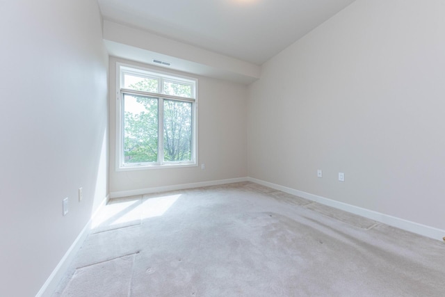 spare room featuring light carpet, baseboards, and visible vents