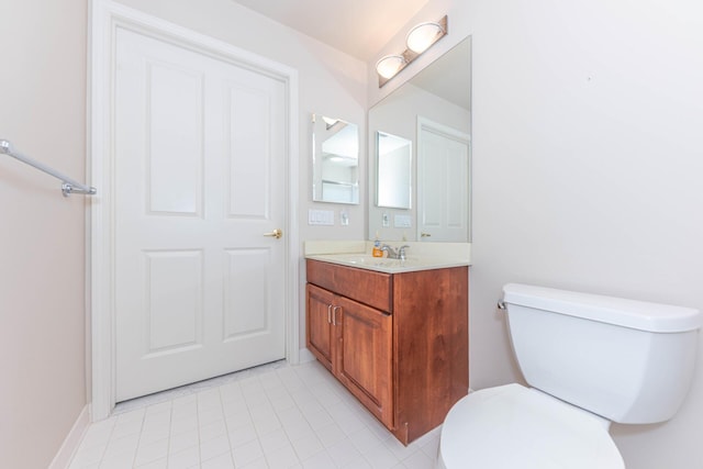 bathroom featuring toilet, baseboards, tile patterned floors, and vanity