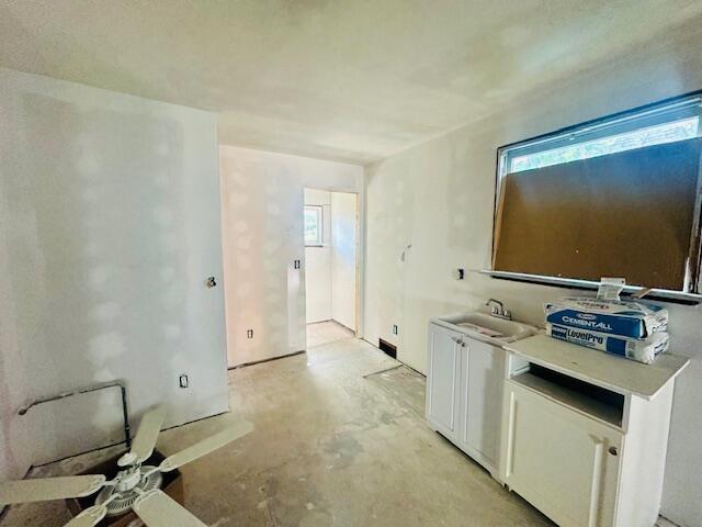 505 Ramsdell St, Manistee, MI 49660 - kitchen featuring concrete floors, white cabinets, healthy amount of natural light, and light countertops