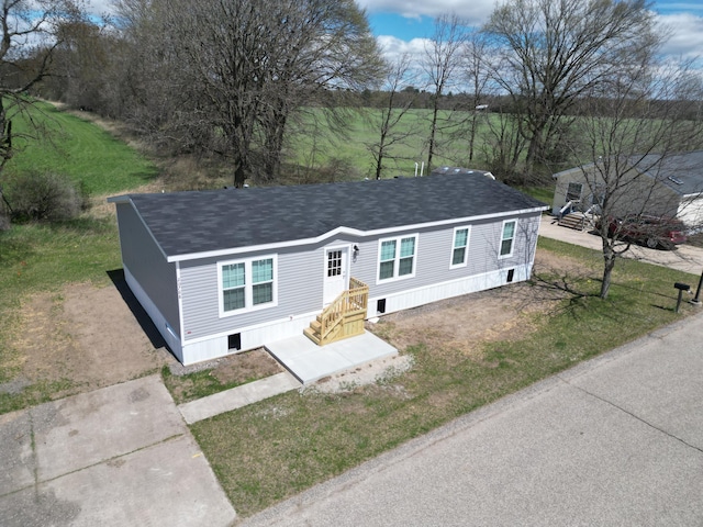 view of front of home with roof with shingles and a front yard