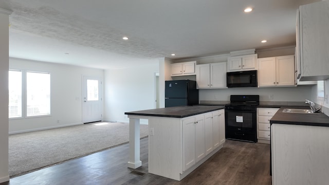 kitchen with a sink, black appliances, open floor plan, a kitchen island, and dark countertops