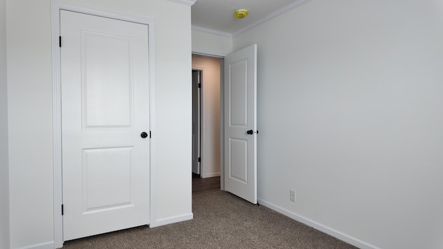 unfurnished bedroom featuring baseboards, ornamental molding, and carpet