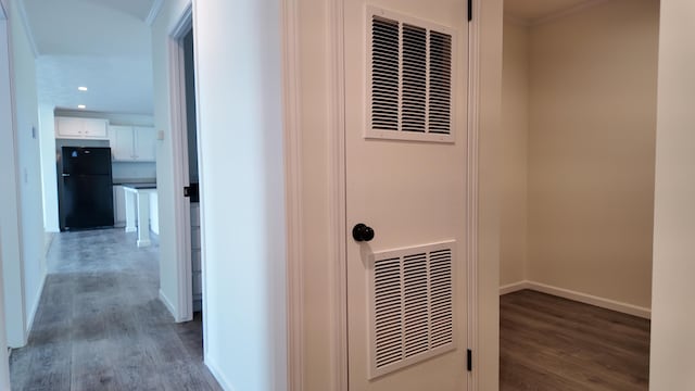 interior space with freestanding refrigerator, a heating unit, recessed lighting, baseboards, and wood finished floors