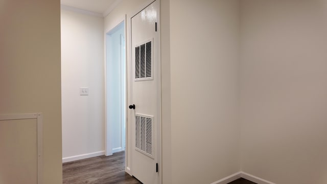 hall featuring baseboards, ornamental molding, a heating unit, and dark wood-style floors