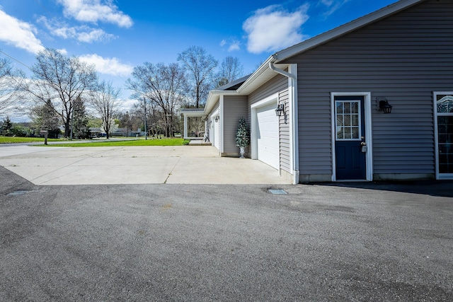 9379 Cook St, Montague, MI 49437 - view of patio / terrace featuring a garage and asphalt driveway
