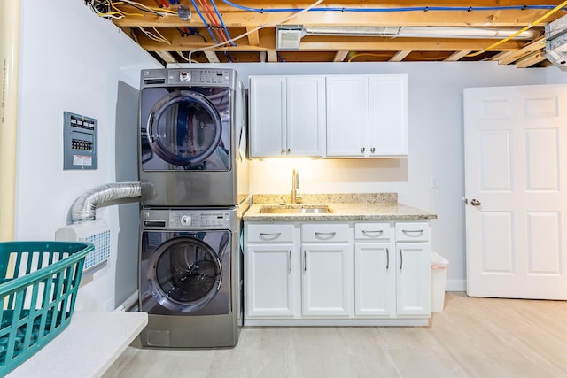 9379 Cook St, Montague, MI 49437 - laundry room with stacked washer / dryer, cabinet space, and light wood finished floors