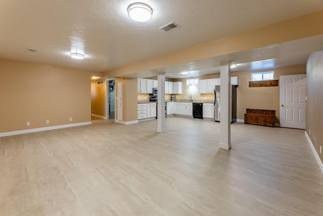 9379 Cook St, Montague, MI 49437 - below grade area with light wood-type flooring, baseboards, and freestanding refrigerator