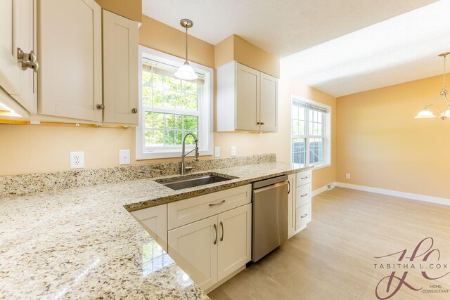 9379 Cook St, Montague, MI 49437 - kitchen with dishwasher, a sink, decorative light fixtures, light wood-type flooring, and light stone countertops