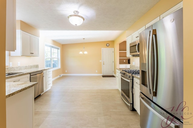 9379 Cook St, Montague, MI 49437 - kitchen featuring stainless steel appliances, white cabinetry, light stone countertops, decorative light fixtures, and baseboards