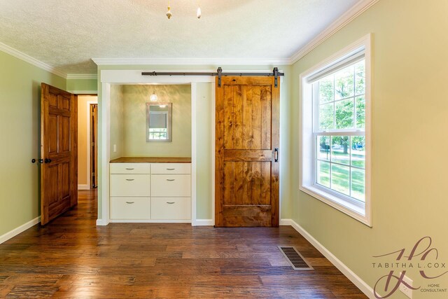 9379 Cook St, Montague, MI 49437 - bedroom featuring crown molding, dark wood-type flooring, multiple windows, a barn door, and baseboards