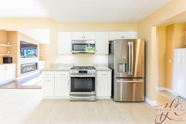 9379 Cook St, Montague, MI 49437 - kitchen with stainless steel appliances, white cabinetry, and light stone counters