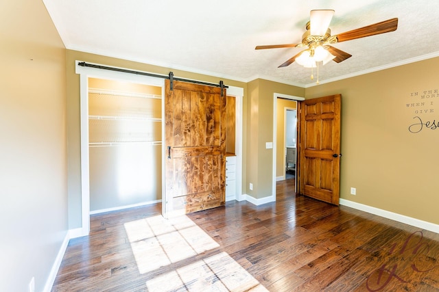 9379 Cook St, Montague, MI 49437 - unfurnished bedroom featuring a barn door, wood finished floors, baseboards, a closet, and crown molding