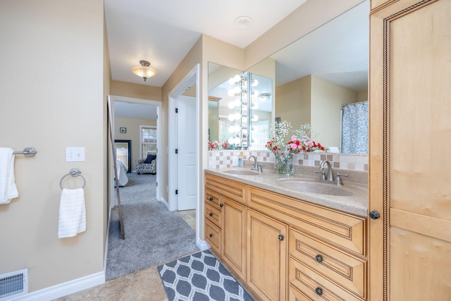 full bath featuring a sink, double vanity, baseboards, and visible vents
