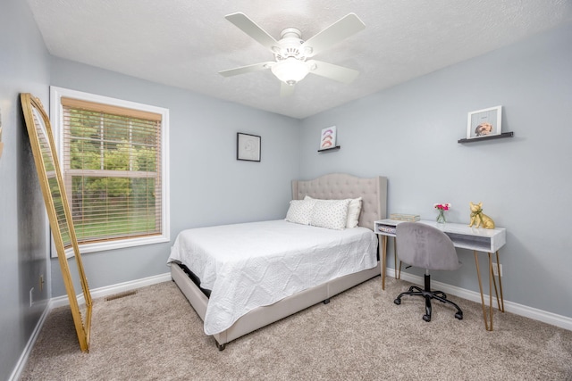carpeted bedroom with visible vents, baseboards, and a ceiling fan