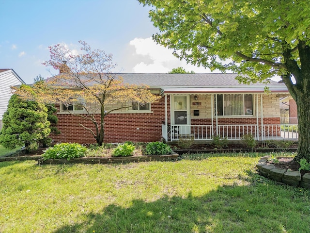 single story home with covered porch, brick siding, a front yard, and a chimney