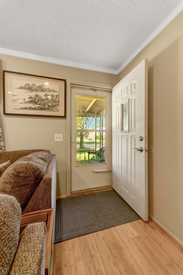 entryway featuring light wood-style floors, a textured ceiling, and baseboards