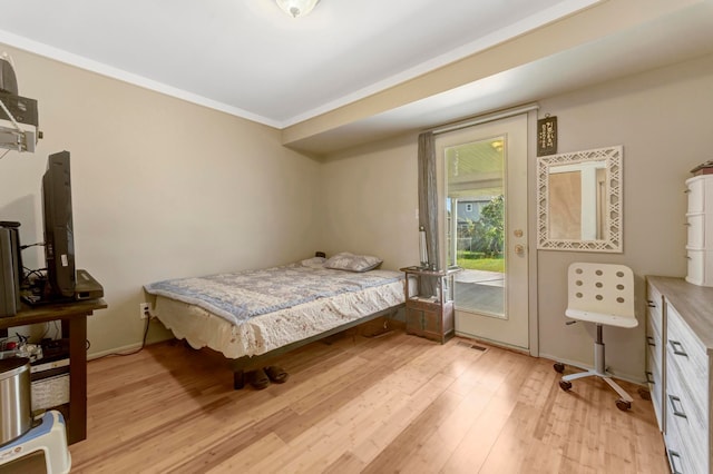 bedroom with access to outside, light wood-style floors, and crown molding